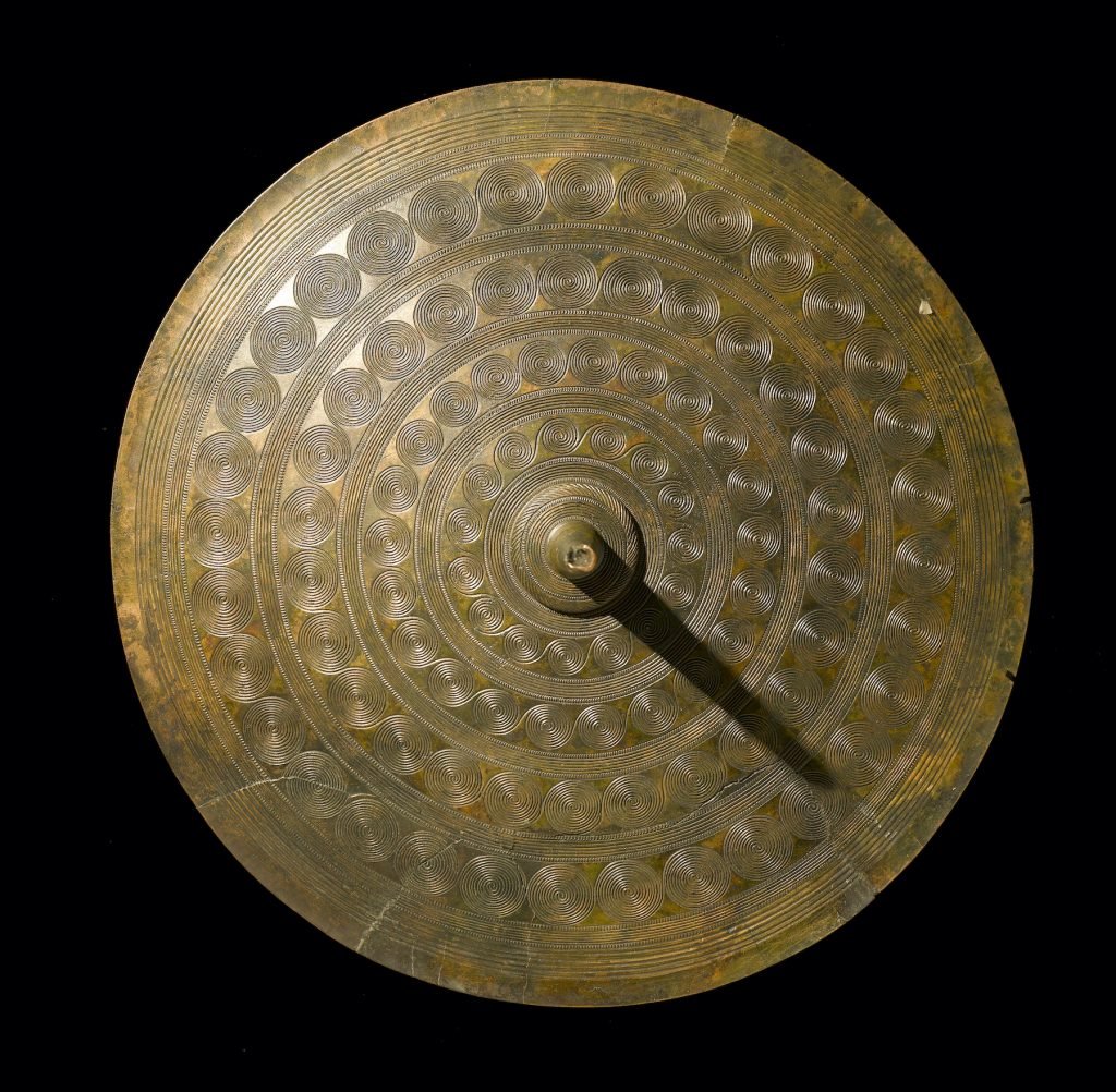 Decorated sun-disc from a woman’s belt (ca. 1400 BC), Langstrup, Frederiksborg Amt and Vellinge, Fyn, Denmark. Collection of the National Museum of Denmark. Photo by Roberto Fortuna and Kira Ursem, CC-BY-SA.