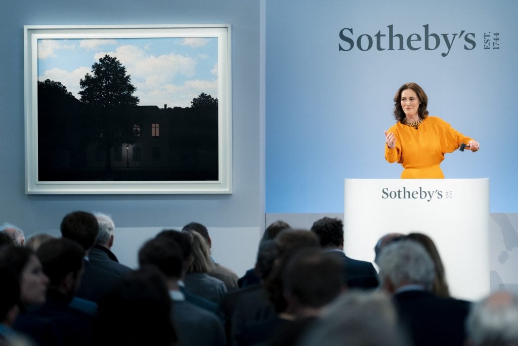 Sotheby's Helena Newman with René Magritte, L'empire des lumières (1961). Courtesy Sotheby's