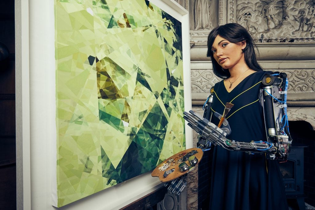 Ai-Da Robot with one of her paintings. Photo by Nicky Johnson.