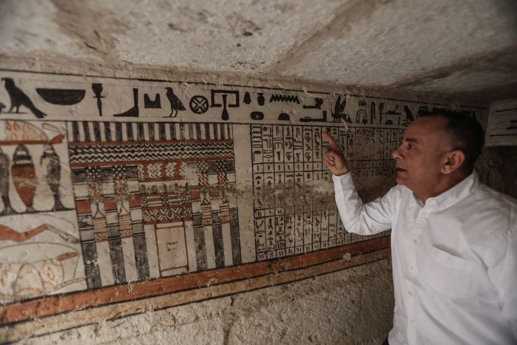 Mostafa Waziri, the head of Egypt's Supreme Council of Antiquities, inspects one of the five ancient Pharaonic tombs. Photo: Stringer/Anadolu Agency via Getty Images.