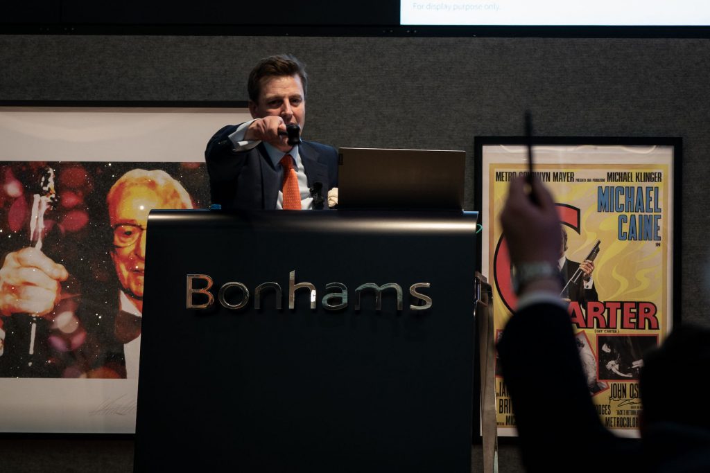 A man bids during the Sir Michael Caine collection sale at Bonhams in London, March 2, 2022. (Photo by Aaron Chown/PA Images via Getty Images)