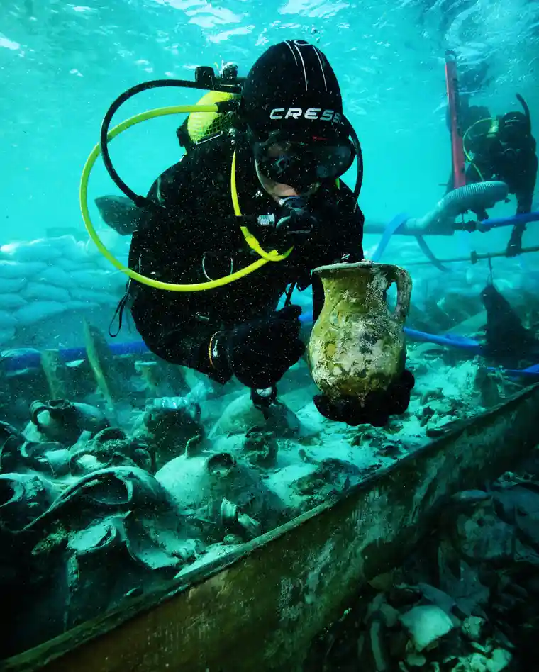 A diver recovers an artifact from the Spanish shipwreck. Photo by Jose A Moya/Arqueomallornauta - Consell de Mallorca, Universitat de Barcelona, Universidad de Cádiz, Universitat de les Illes Balearsc