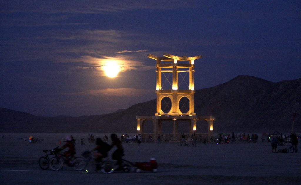 The Temple of Atonement by David Best comes to life in the evening as the full moon rises over the desert at Burning Man, 2007. (Photo by Michael Macor/The Chronicle, via Getty Images.)