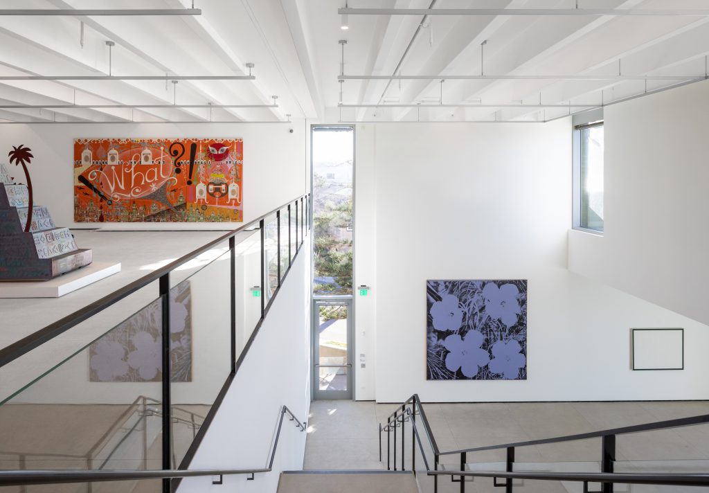 . Installation view of the Marshall Gallery and Cohn Gallery inside MCASD’s new La Jolla flagship by Selldorf Architects. Courtesy of Selldorf Architects. Photo Credit: Nicholas Venezia. Artwork from left Lari Pittman, How Sweet the Day After This and That, Deep Sleep Is Truly Welcomed, 1988. Acrylic, enamel, and five framed works on paper on wood panels overall (three panels): 96 1/16 × 192 1/8in. (244 × 488cm). Collection of Matthew and Iris Strauss. Andy Warhol, Flowers, 1967. Silkscreen ink and synthetic polymer paint on canvas, 115 1/2 x 115 1/2 in. (293.4 x 293.4 cm); framed: 116 x 116 x 1 1/2 in. Museum purchase with contributions from the Museum Art Council Fund.