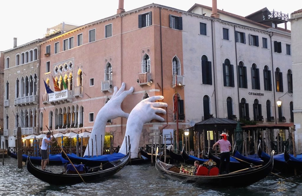 Lorenzo Quinn, Support, in Venice, Italy, on May 19, 2017. The artwork, featuring two hands holding up the Ca' Sagredo Hotel, was part of the the 57th International Art Exhibition of the Venice Biennale, and was intended to highlight climate change. Photo: Adam Berry/Getty Images.