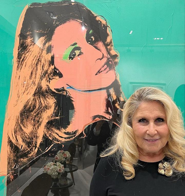 "Baby" Jane Holzer in front of one of the portraits Andy Warhol did of her. Photo by Simon de Pury.