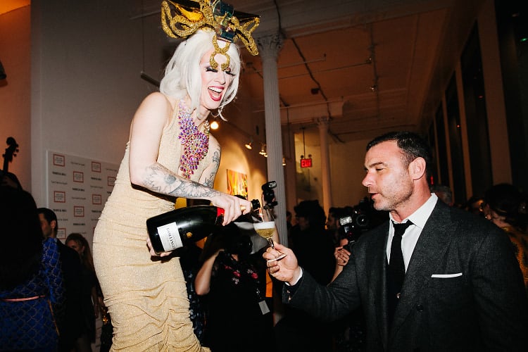 A stilt walker pours champagne for Liev Schreiber at the Tribeca Ball. Photo courtesy of the New York Academy of Art. 