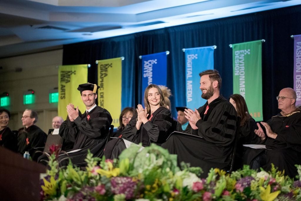 Evan Spiegel and Miranda Kerr, who are repaying the student loan debt for the class of 2022 at Otis College of Art and Design, at the school's commencement ceremony with Bobby Berk, star of Netflix's <em>Queer Eye</em>. All three received honorary degrees. Photo courtesy of Otis College of Art and Design, Los Angeles.