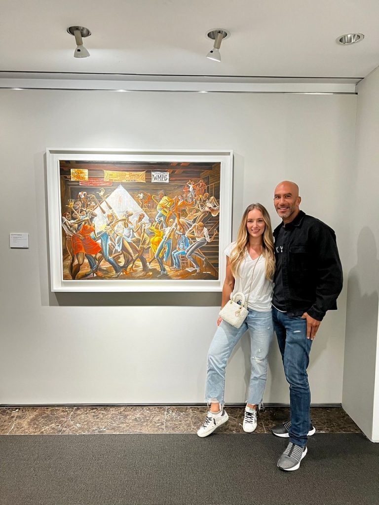 Bill Perkins and his fiance Lara Sebastian at Christie's with Ernie Barnes's The Sugar Shack(1976). Perkins won the work for $15.3 million after a lengthy bidding war. Image courtesy Bill Perkins.