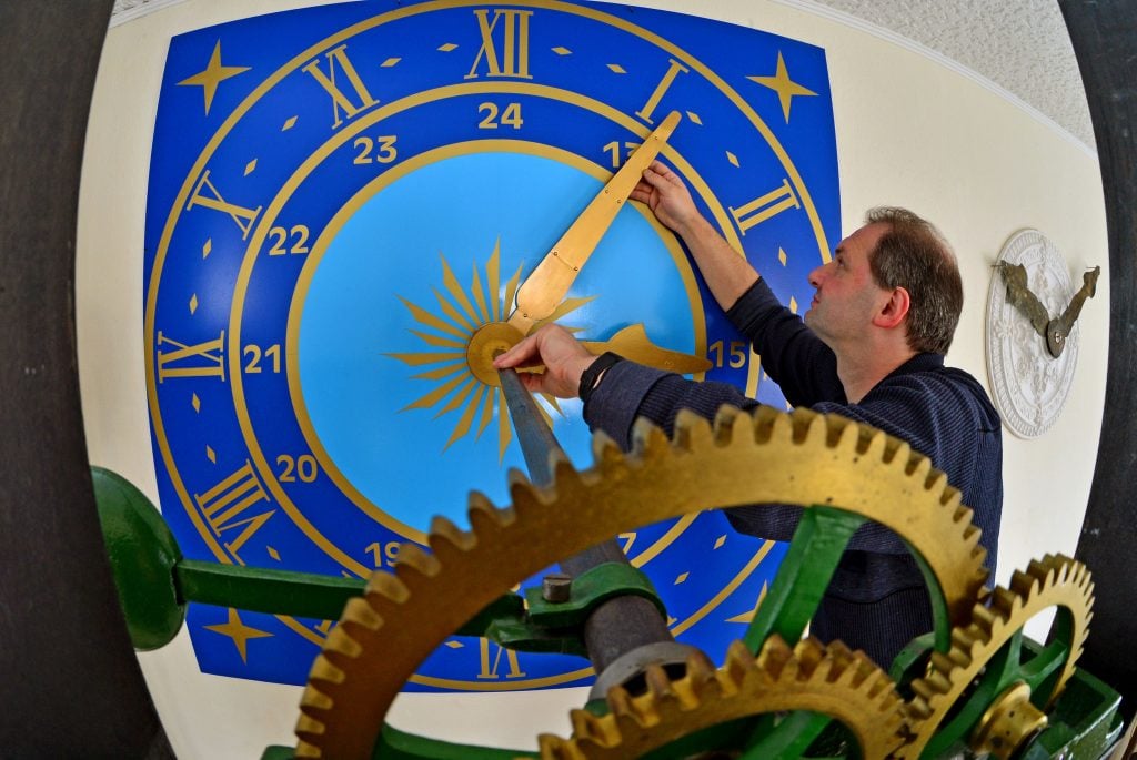 Museum director Dirk Roeder stands in front of an Art Nouveau dial in the Technical Clock Museum in Chemnitz, Germany, October 25, 2013. Photo: Hendrik Schmidt/picture alliance via Getty Images.