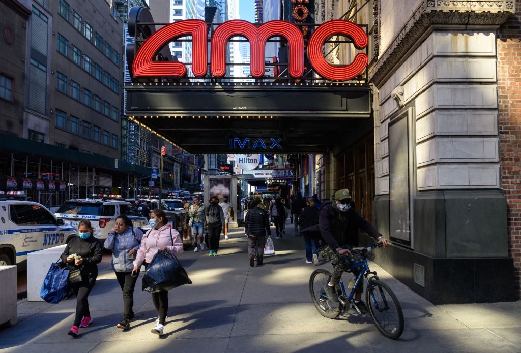 People walk past an AMC and IMAX movie theatre in the theatre district near Broadway on May 6, 2021 in New York City. (Photo by Angela Weiss / AFP) (Photo by ANGELA WEISS/AFP via Getty Images)