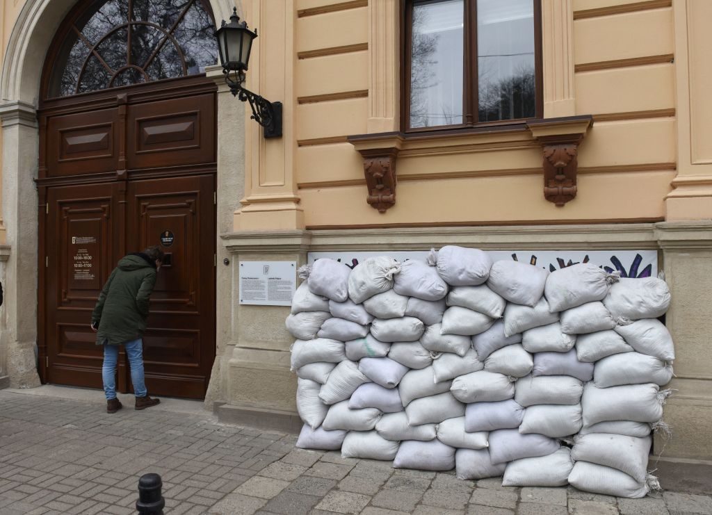 A man stands looks through a door of the Lviv National Art Gallery with windows protected by sandbags in the western Ukrainian city of Lviv on March 7, 2022, 12 days after Russia launched a military invasion on Ukraine. Photo: Yuriy Dyachyshyn / AFP via Getty Images.