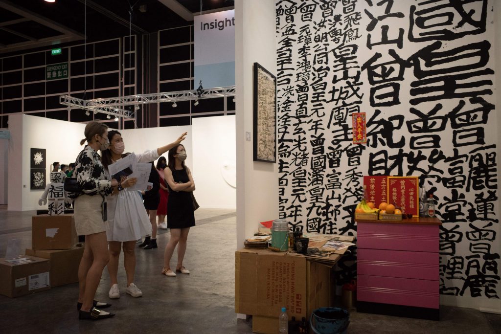 Visitors look at an art work on the second preview day of Art Basel in Hong Kong on May 26, 2022