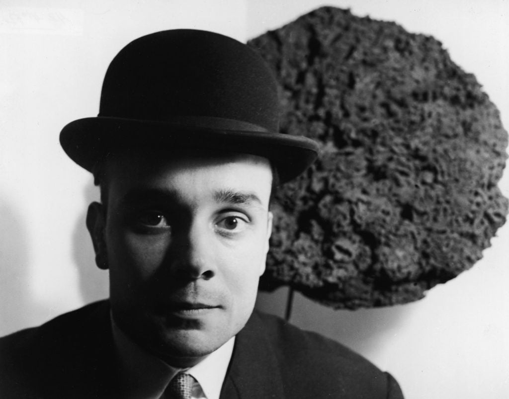 French artist Yves Klein in a bowler hat as he stands in front of one of his Blue Sponge Sculptures, France, late 1950s. The first public display of these sculptures, which were made from different sized sponges that had been dyed blue, was on June 15, 1959 at the Galerie Iris Clert in Paris, France. Photograph by Express Newspapers/Getty Images.