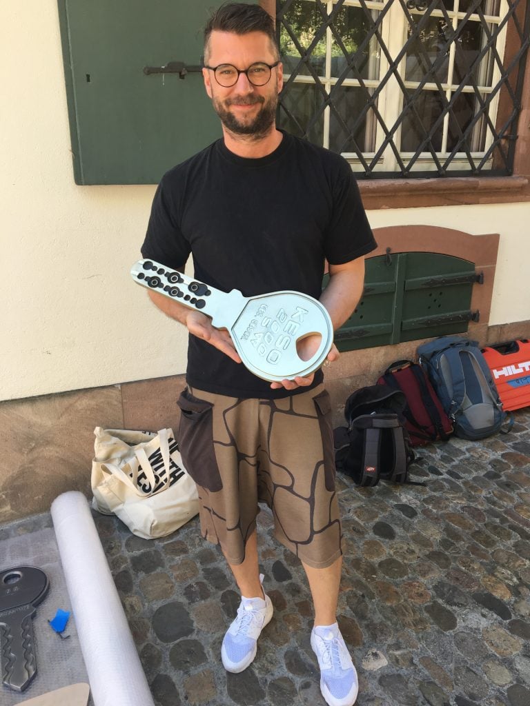 Curator Samuel Leuenberger holding a giant key to Basel, Switzerland, commissioned as part of an Art Basel project with the artist Amanda Ross-Ho. Courtesy of Samuel Leuenberger.
