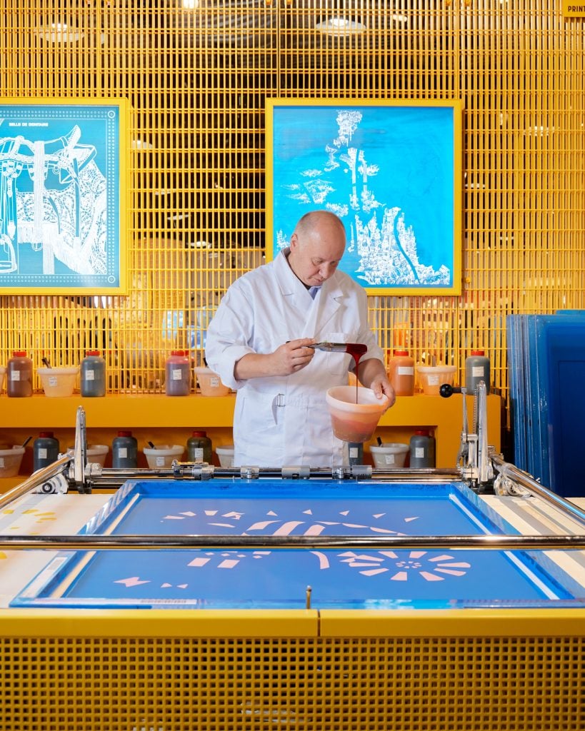 A highly-trained Hermès artisan in the intricate process of scarf dyeing. Photo: William Jess Laird, courtesy of Hermès.