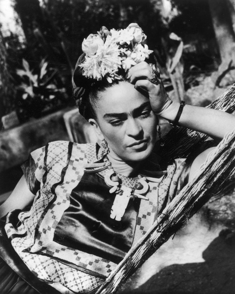Frida Kahlo wearing a folk costume and flowers in her hair (circa 1950). Photo by Hulton Archive/Getty Images.