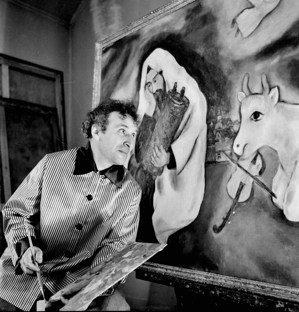 Marc Chagall in August 1934, in front "Solitude" (1933).  Photo by Roger Viollet via Getty Images.