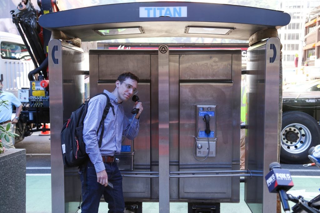 A man poses with the last payphone kiosk in New York City. Photo courtesy of LinkNYC. 