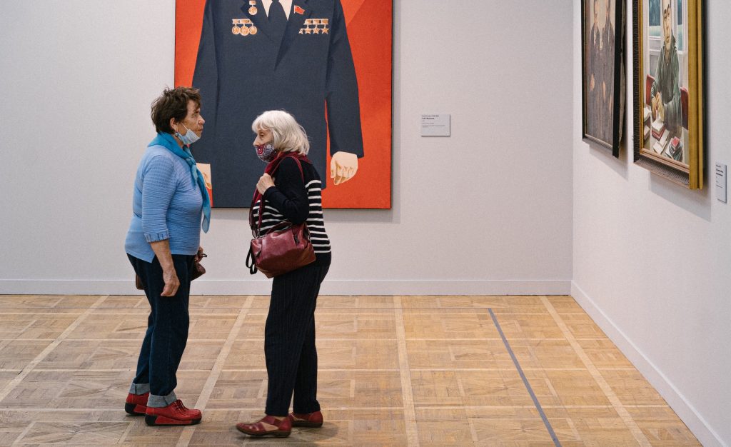 Elderly women look at paintings at a museum in Moscow, Russia. Photo by Grisha Besko, public domain from Pexels.