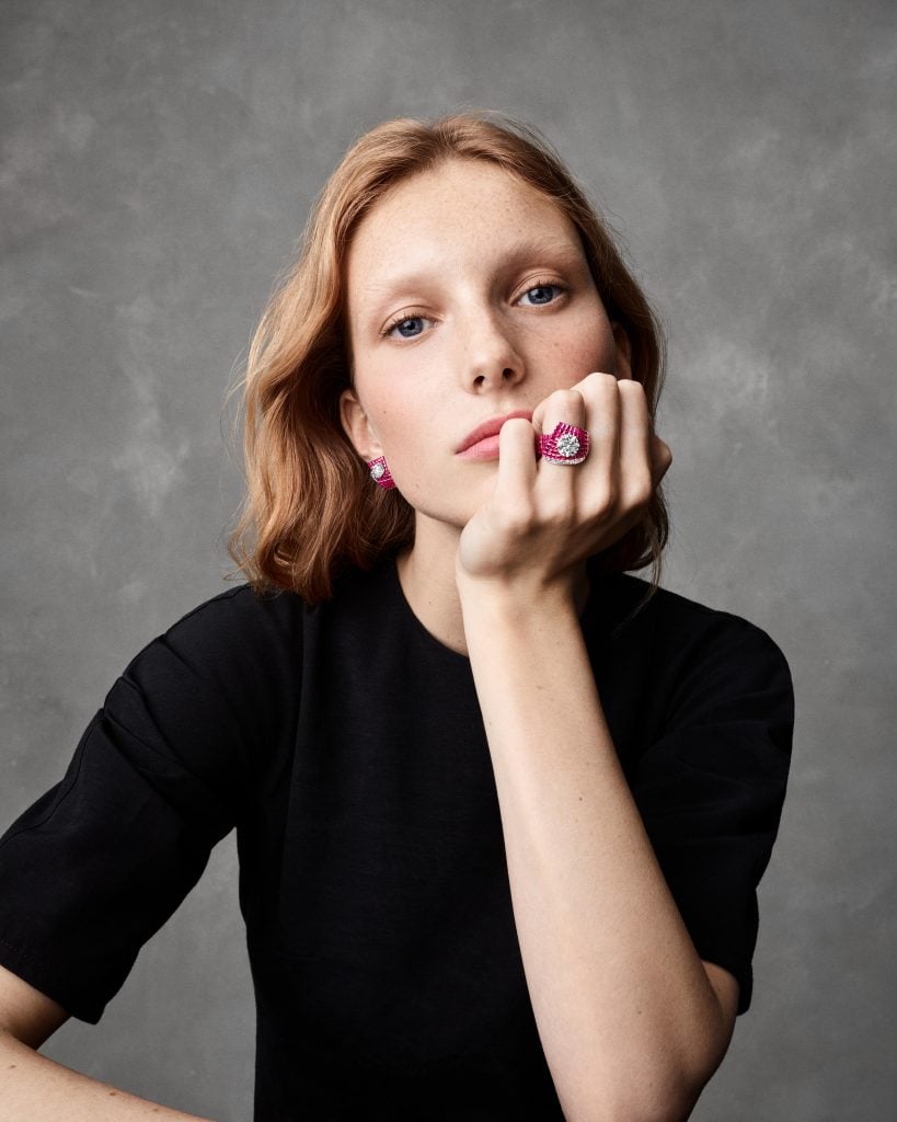 A model wears the Satin Mysterieux ring and earrings composed of white and rose gold, diamonds and rubies. Photo: Marc de Groot. Courtesy of Van Cleef & Arpels.