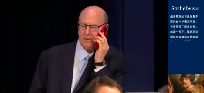 George Wachter, Sotheby's co-chairman of Old Master paintings, taking a multimillion-dollar call with an eye-catching device. Screen capture from the livestream of Sotheby's modern evening sale in May 2023.