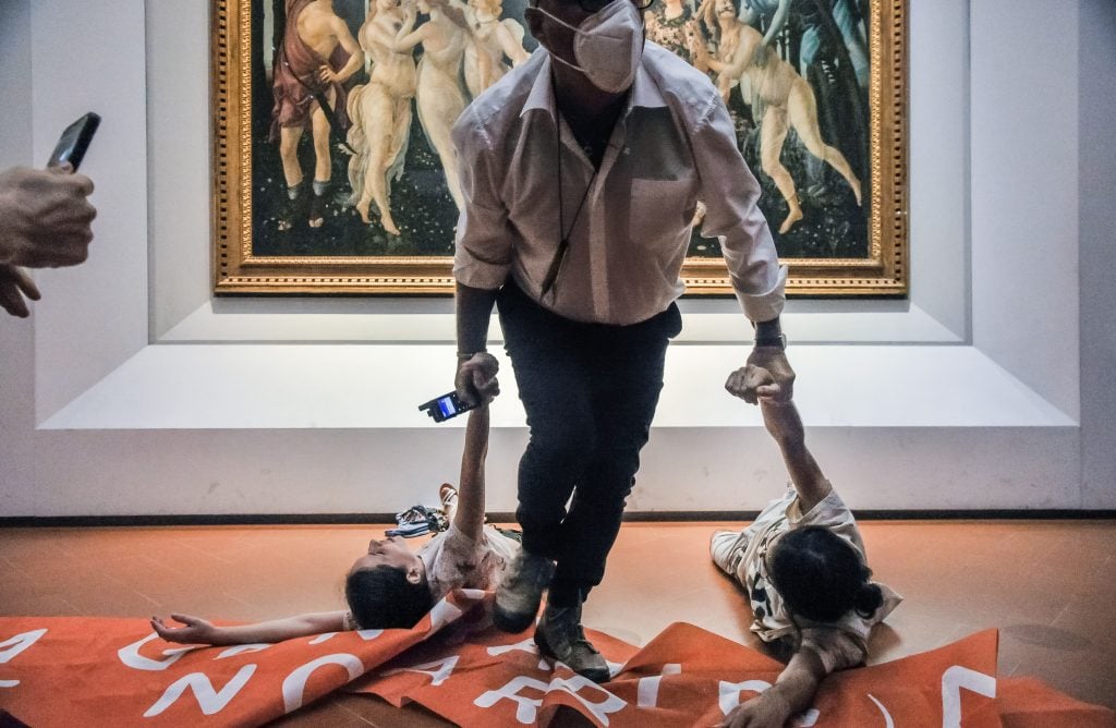 Protesters from the action group Ultima Generazione being dragged out of the Uffizi in Florence, Italy, after gluing their hands to the glass covering Sandro Botticelli's Primavera. Photo by Laura Lezza/Getty Images.