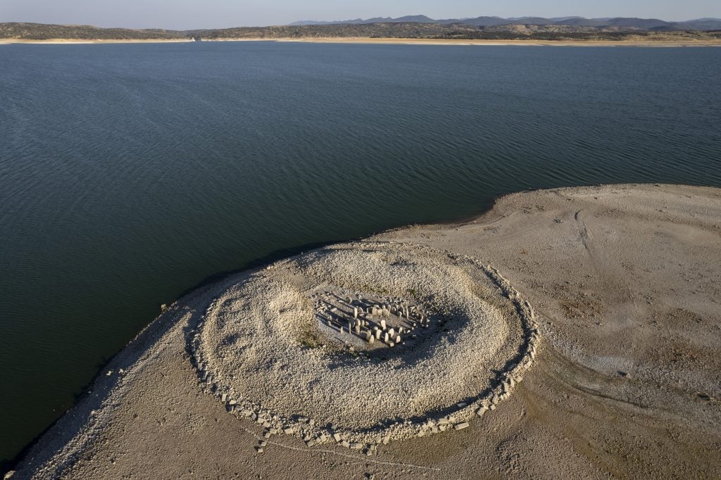 The Dolmen of Guadalperal, sometimes also known as "The Spanish Stonehenge" is seen above the water level at the Valdecanas reservoir, which is at 27 percent capacity, on July 28, 2022 in Caceres province, Spain. Photo by Pablo Blazquez Dominguez/Getty Images.