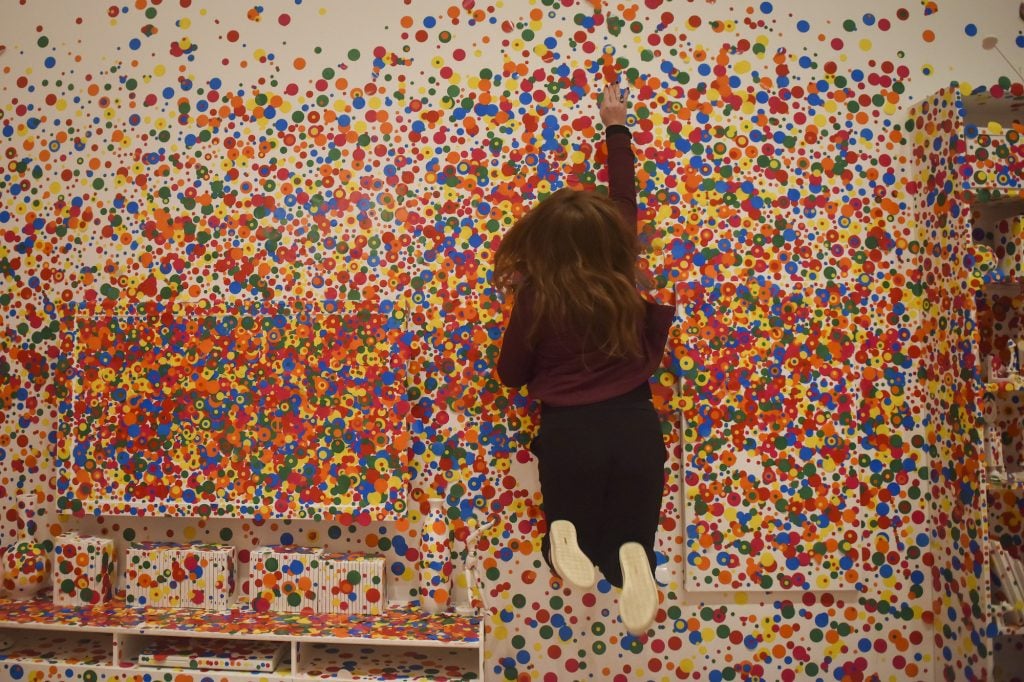 Anna Tulchinskaya leaps to apply the absolute last dot to the Obliteration Room on the final day of the Yayoi Kusama: Infinity Mirrors exhibit at the Smithsonian Institute's Hirshhorn Museum on Sunday, May 14, 2017, in Washington, DC. A week ago, Tulchinskaya waited in line two hours for the exhibit before the visitors' line was cut off just in front of her. She said, "It was close enough to hurt. The guy in front of me screamed." She later won an Instagram lottery to be able to apply the absolute final dot of the show. She said the lottery question "was 'What would you obliterate in the Obliteration Room if you were to come in?' and I said I would obliterate the highest spot I could reach...I don't jump very high and I'm not particularly tall, so it was much less impressive than I thought it would be. But I did not waste that opportunity." Since the exhibit opened in February, visitors have applied almost 800k stickers around the room that started completely white. Photograph by Jahi Chikwendiu/The Washington Post via Getty Images.