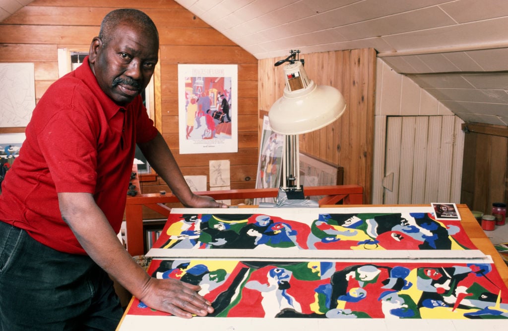 Renowned African-American artist and painter Jacob Lawrence poses in his Seattle (1986). Washington studio. Photo by George Rose/Getty Images. 