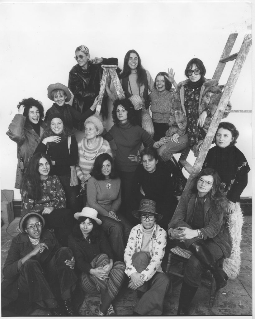A.I.R. Gallery founding members, 1974. Front row Howardena Pindell, Daria Dorosh, Maude Boltz, and Rosemary Mayer. Second row, Mary Grigoriadis, Agnes Denes, Louise Kramer, and Loretta Dunkelman. Third row, Barbara Zucker (slightly behind), Patsy Norvell, Sari Dienes, Judith Bernstein, and Dotty Attie (on the ladder). Fourth row, Laurace James, Nancy Spero, Pat Lasch, and Anne Healy. Photo by David Attie, courtesy of the Fales Library and Special Collections, NYU.