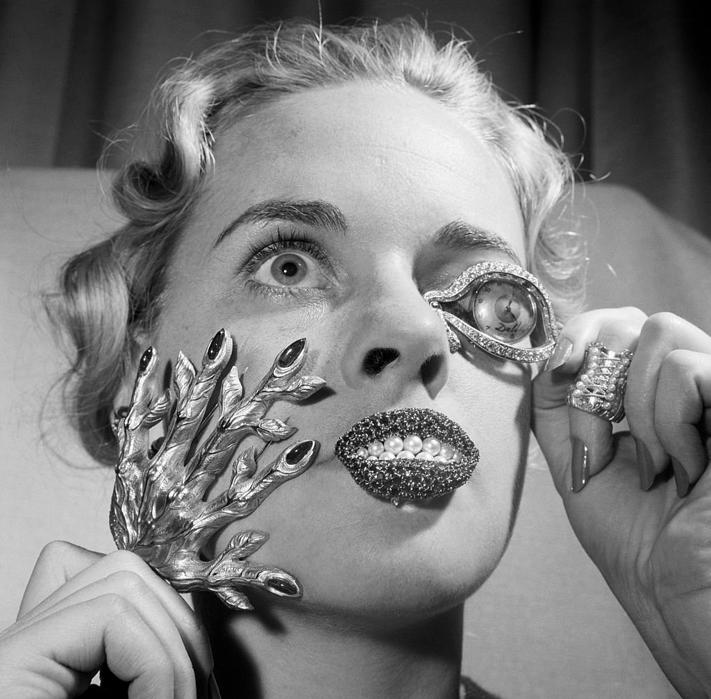 Madelle Hegeler wears jewelry by Salvador Dalí in 1959: a sculptured gold hand, ruby lips with pearl teeth, an Eye of Time watch worn like a monocle, and a Corset Ring. Courtesy of Getty Images.
