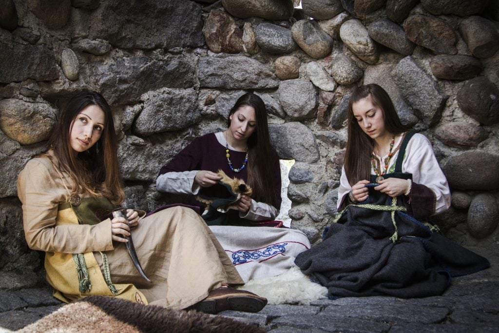 Historical reenactment of women working with textiles in a Viking village, 10th century. Photo by DeAgostini/Getty Images.