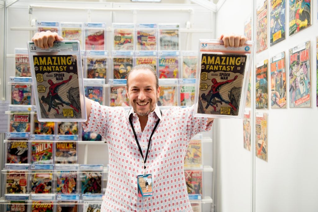 Vincent Zurzolo poses with two issues of Amazing Fantasy No. 15 (1962), the first appearance of Spider-Man at London Super Comic Con in 2017. Photo by Ollie Millington/Getty Images.