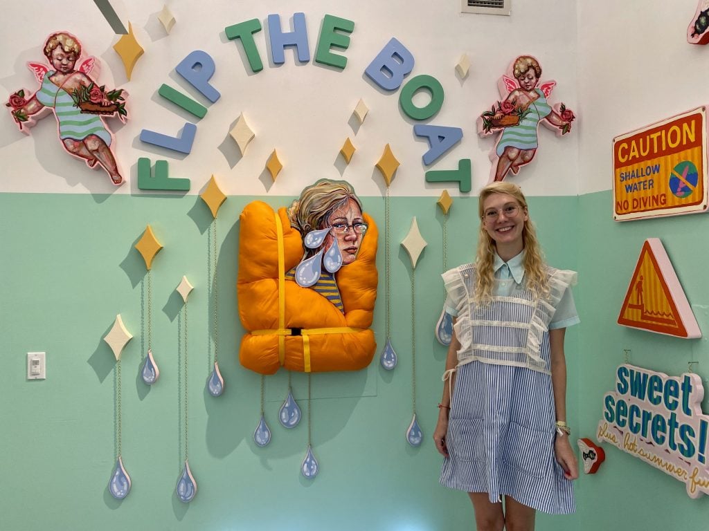 Emily Furr and her work in "Flip the Boat" curated by Ariel Arakas at New York's SPRING/BREAK Art Show 2022. Photo by Sarah Cascone.