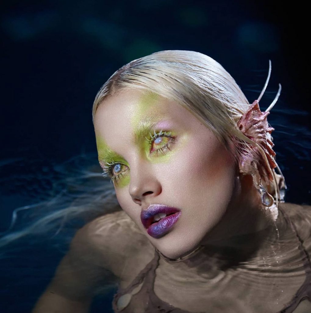 Ffrench wore webbed-ear prosthetics with iridescent green shimmer and white contact lenses for Byredo’s Syren palette campaign. Courtesy of Isamaya Ffrench.