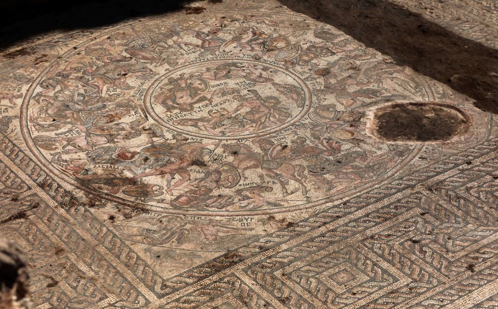 This picture taken on October 12, 2022 shows a view of a mosaic floor dating to the Roman era being excavated in the city of al-Rastan in Syria's west-central province of Homs, after its discovery was announced by Syria's General Directorate of Antiquities. - Syria revealed on October 12 a remarkably intact 1,600-year-old Roman-era mosaic including depictions of warriors in the Trojan War, with authorities hailing it as one of the 
