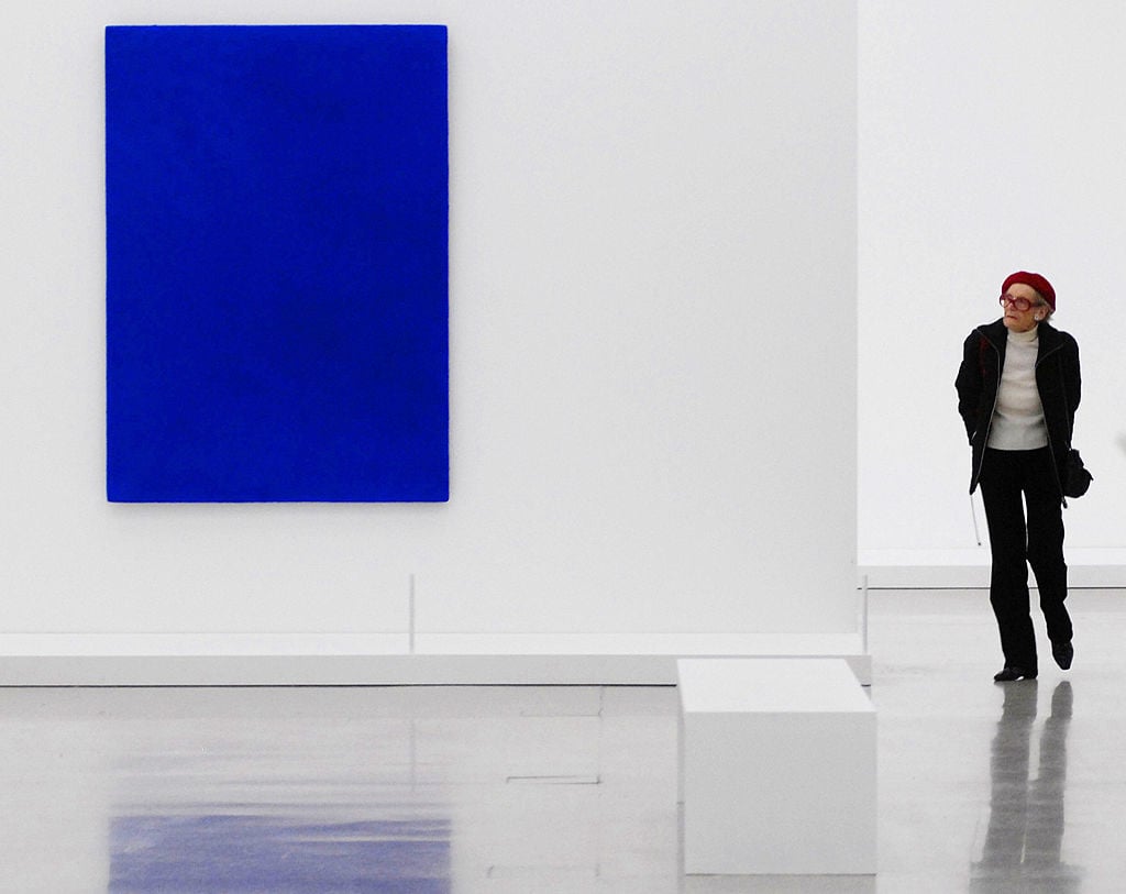 A visitor looks at paintings by French artist Yves Klein during the exhibition "The Blue Revolution" at the Mumok museum in Vienna, March 2007. Photo: Samuel Kubani / AFP via Getty Images.