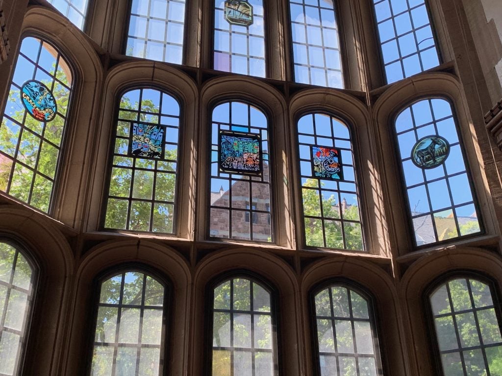 Barbara Earl Thomas's new windows in the Hopper College dining hall, alongside some of the original medallions. Photo courtesy of Yale University, New Haven.