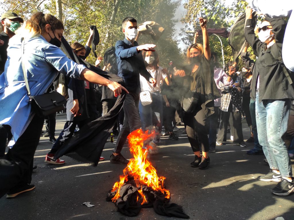 Iranian protesters set their scarves on fire while marching down a street on October 1, 2022, in Tehran, Iran. Protests over the death of 22-year-old Iranian Mahsa Amini have continued to intensify despite crackdowns by the authorities. The 22-year-old Iranian fell into a coma and died after being arrested in Tehran by the morality police, for allegedly violating the country's hijab rules. Photo by Getty Images.