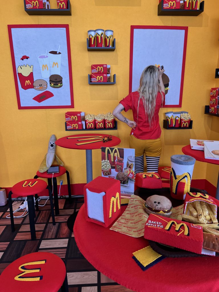 Lucy Sparrow puts the finishing touches on her Mcdonald’s installation at Scope Miami Beach. Photo by Jo Brooks PR. 