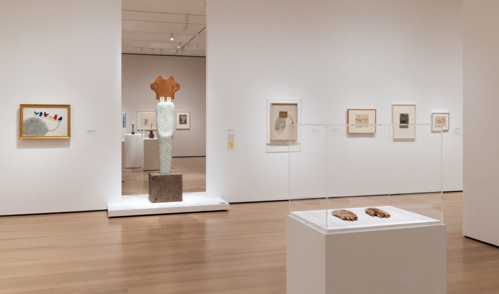 Installation view of "Meret Oppenheim: My Exhibition" on view at the Museum of Modern Art, New York. Her sculpture <em>The Green Spectator</em> (1959) blocks a doorway between galleries, a design choice envisioned by the artist in set of 1983 drawings for a possible retrospective of her work. Photo by Jonathan Muzikar, courtesy of the Museum of Modern Art, New York. 