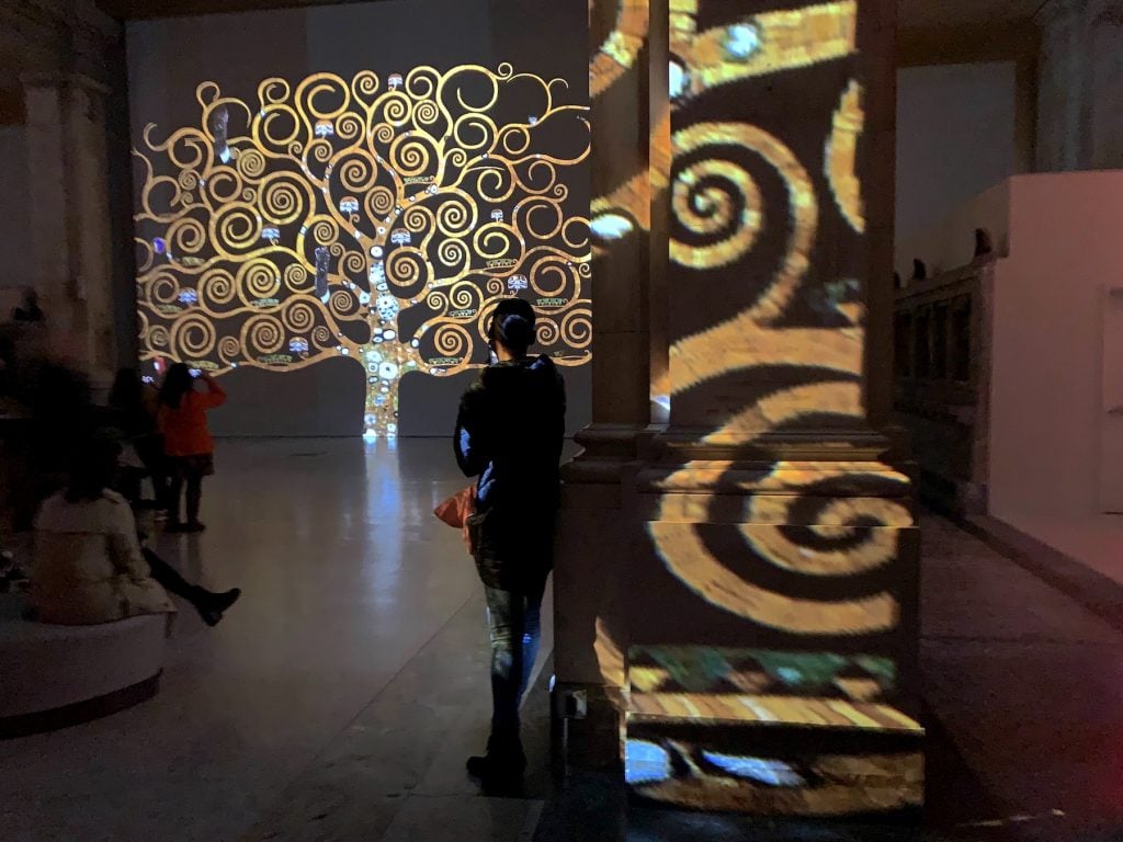 Visitors observe the Tree of Life segment of "Gustav Klimt: Gold in Motion" 