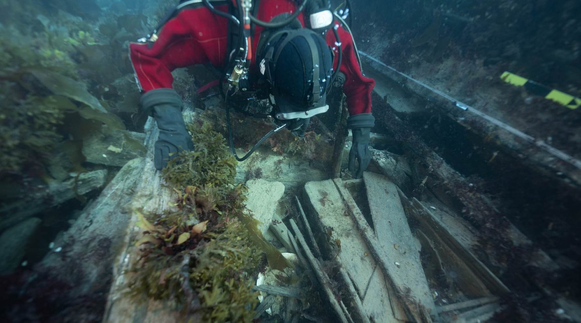 Parks Canada Underwater Archaeologist Jonathan Moore observes a washing basin and an officer's bed place on the lower deck of HMS Erebus, September 2022. Photo: Marc-André Bernier, courtesy of Parks Canada.