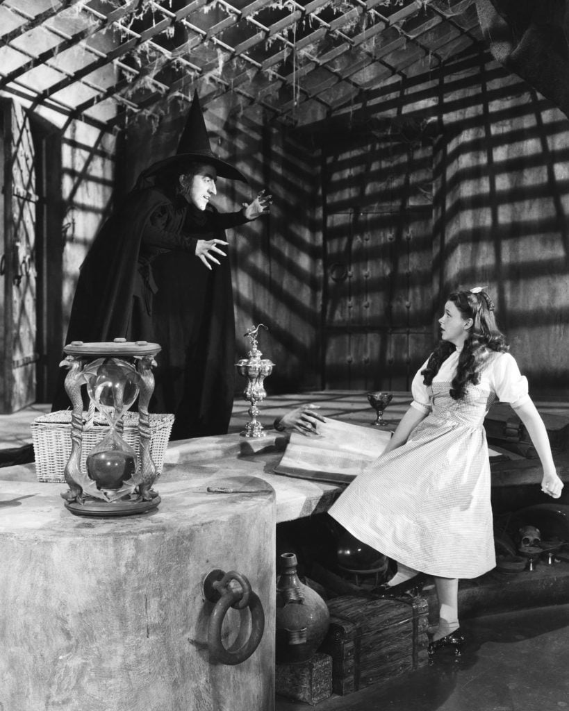 Actors Judy Garland (right) as Dorothy and Margaret Hamilton as the Wicked Witch of the West in the musical film <em>The Wizard of Oz</em> (1939). Photo by Silver Screen Collection/Getty Images.