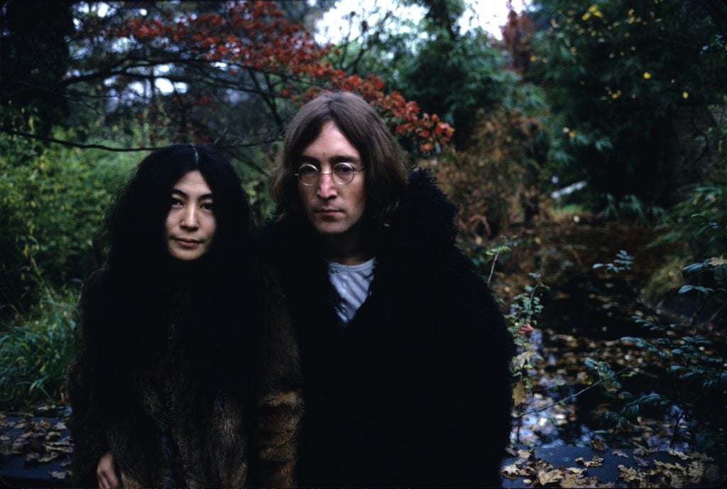 John Lennon and Yoko Ono posing in a park