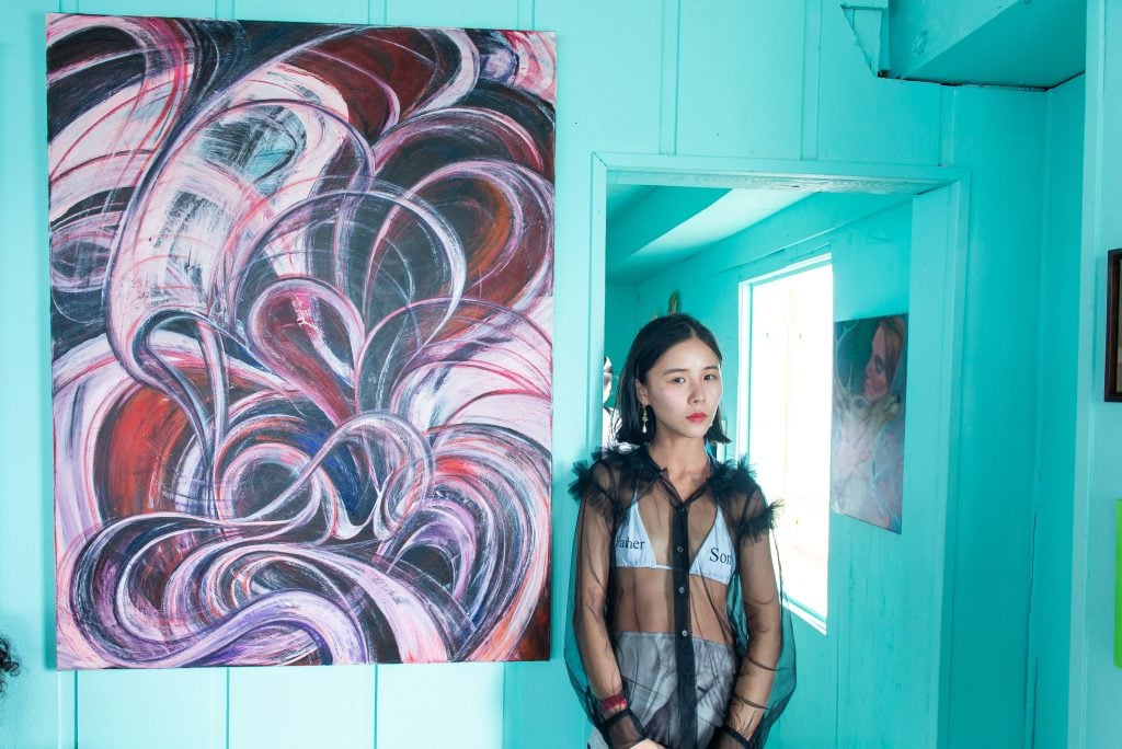 Yuan Fang with her piece Fireworks 07 (2022) at Half Gallery's Stiltsville show. Photo by Justin Namon.