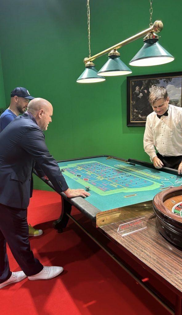 Marc Spiegler trying his hand at the tables in Guillaume Bijl’s installation at Meredith Rosen Gallery, contemplating whether a professional gambling career is in the cards after his imminent departure from Art Basel. Photo courtesy of Kenny Schachter.