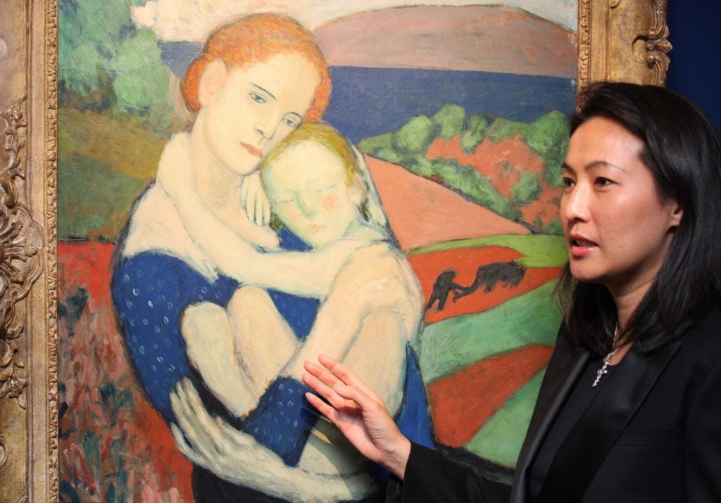 Patti Wong, chairman of Sotheby's Asia, speaks beside a Pablo Picasso painting entitled <i>Mere Tenant un Enfant</i> in Hong Kong at city's first western art selling exhibition "The Modern Masters" on November 25, 2010. Photo credit Ed Jones/AFP via Getty Images