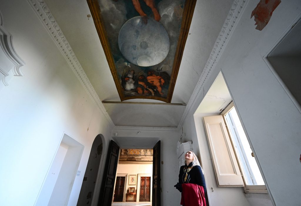 Princess Rita Jenrette Boncompagni Ludovisi looking at <em>Jupiter, Neptune, and Pluto</em>, the only known ceiling painting by Caravaggio, in the Villa Aurora, or Casino di Villa Boncompagni Ludovisi in Rome. Photo by Vincenzo Pinto/AFP via Getty Images.